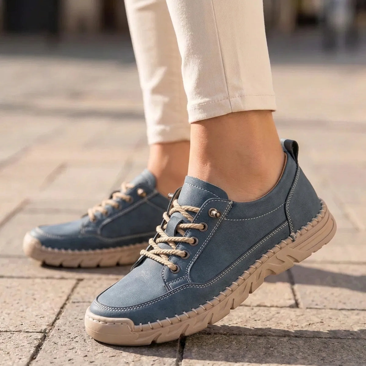 StitchStride slate blue stitched lace-up comfort sneakers worn with cream trousers