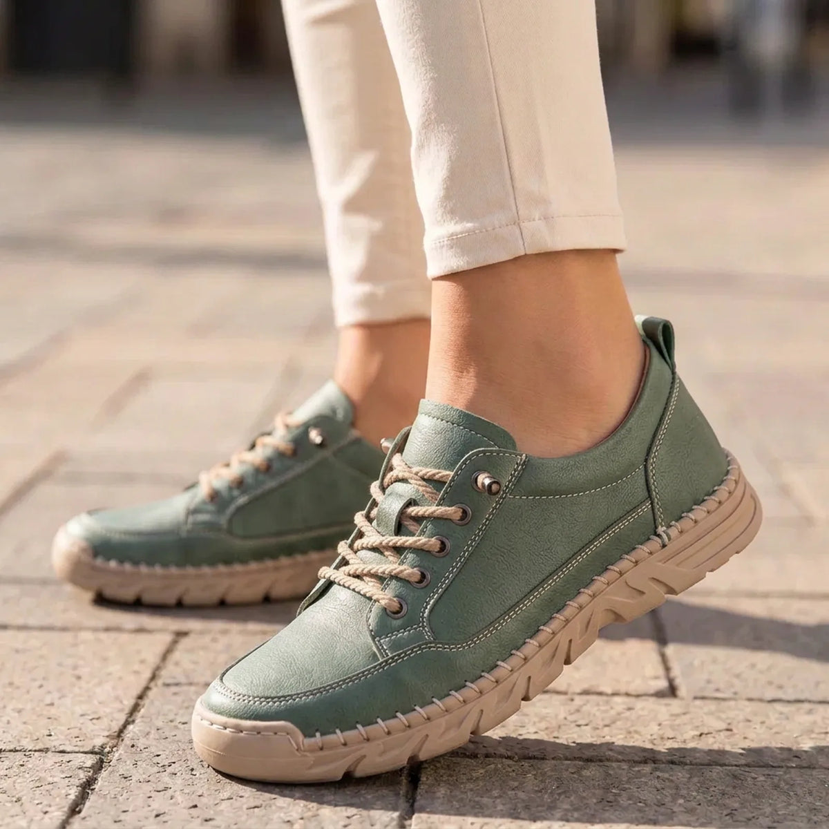 StitchStride sage green stitched lace-up comfort sneakers worn with cream trousers