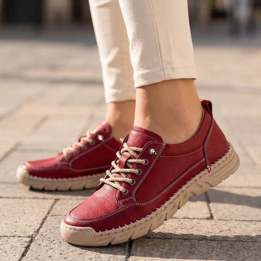 StitchStride red stitched lace-up comfort sneakers worn with cream trousers